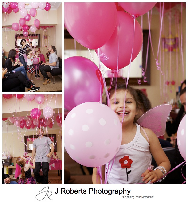 Little girls playing with lots of pink helium balloons at birthday party - sydney party photography 